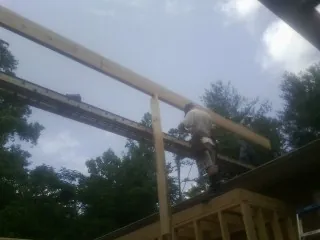 Carpenter setting a ridge beam over a new addition frame — Ice Dam Removal by Roofing Brothers in Ojai