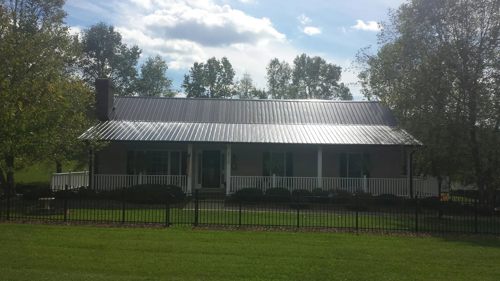 Gray metal roof on a brick ranch with a full width front porch — Gutter Guard Installation work by our crew in Ojai